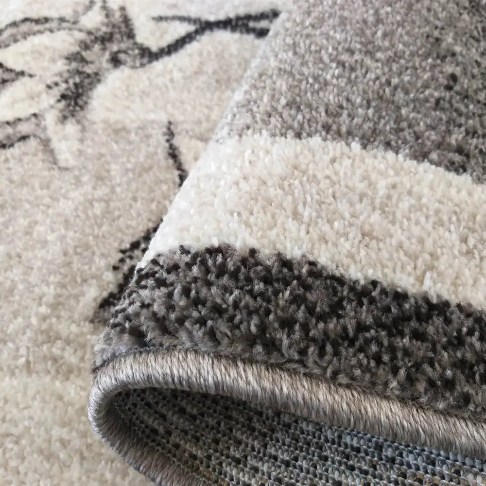 Tepe Otto teppe, nærbilde av hjørne med myk, grå-beige luv og tett, solid kant, fiberdetaljer synlige.