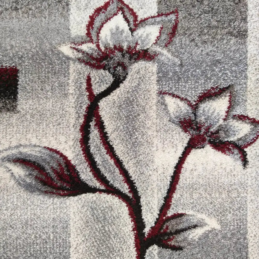 Tepe Otto teppe 160 x 220 cm, nærbilde av grått og rødt blomstermønster på stripet bakgrunn.