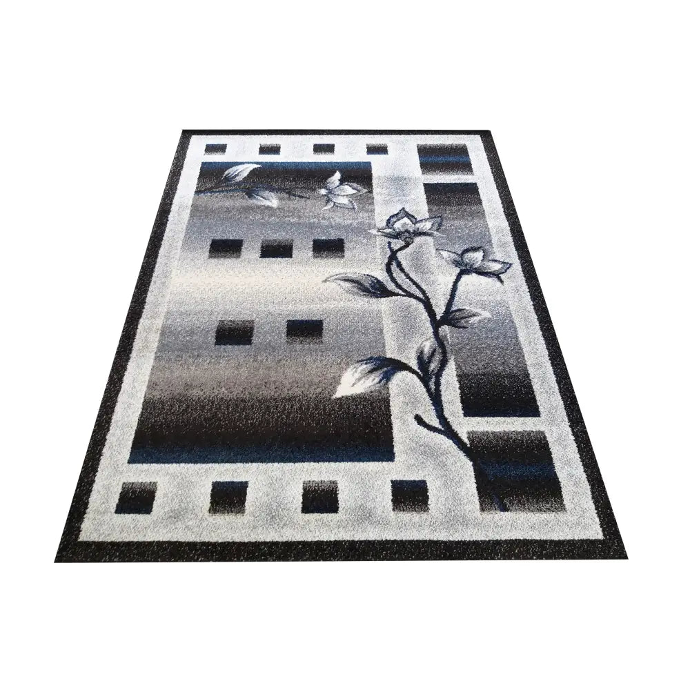 Tepe Otto 02 teppe i grå og blå nyanser, geometriske ruter og blomsterkant sett fra skrå vinkel.