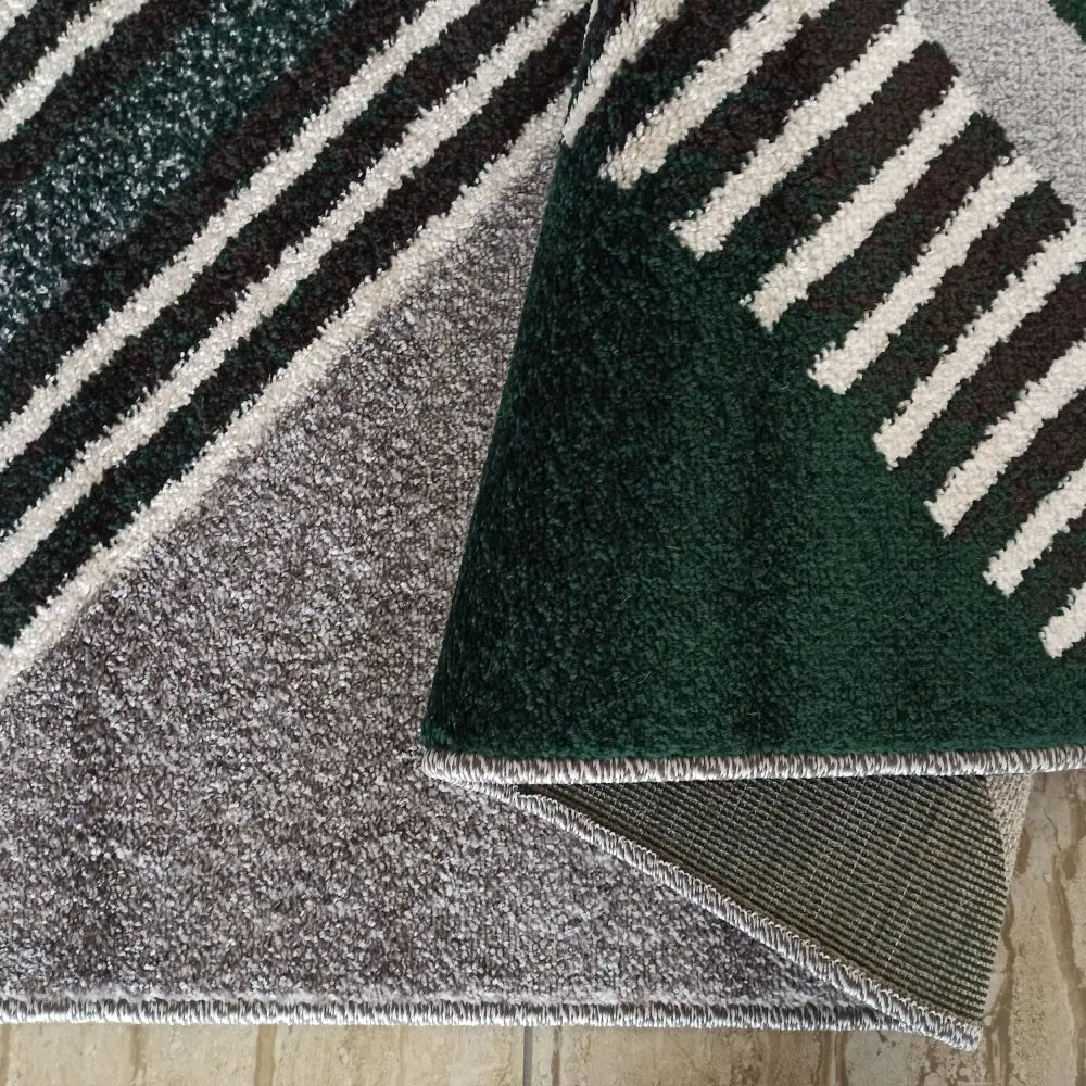 Tepe Otto-teppe i grått og mørkegrønt, nærbilde som viser stripemønster, kanter og underside.