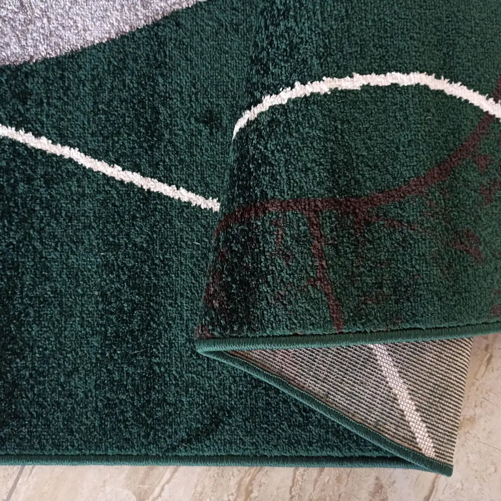 Tepe Otto teppe i grønt, nærbilde av mønster og brettet hjørne som viser undersiden og kantfinish.