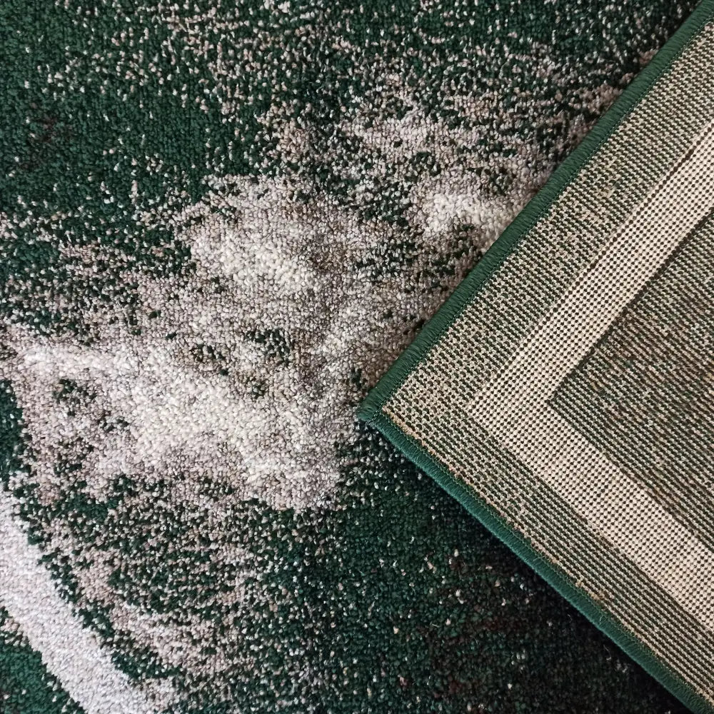 Tepe Otto teppe i grønn og beige, nærbilde av hjørne med synlig tekstur og solid stoffkant.
