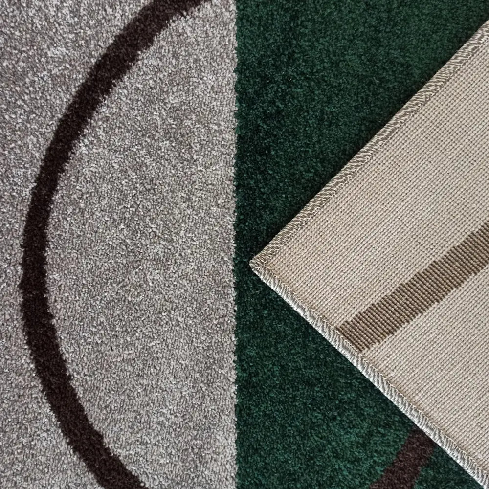 Tepe Otto teppe i grå og mørkegrønn med mørk brun stripe, detalj av underside og kantsøm i hjørnet.