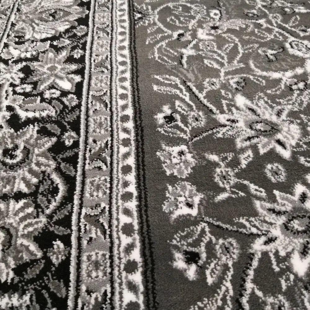 Tepe Oval Eksklusiv teppe i grått og svart, nærbilde av orientalsk mønster, struktur og dekorert kant.