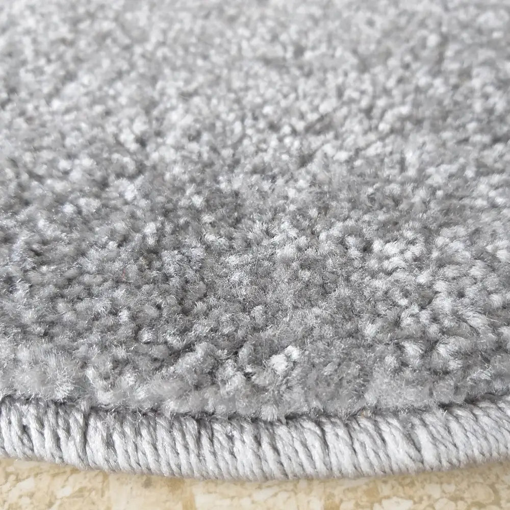 Tepe Portofino grått rundt teppe, nærbilde som fremhever den tykke, myke luven og den solide sydde kanten.