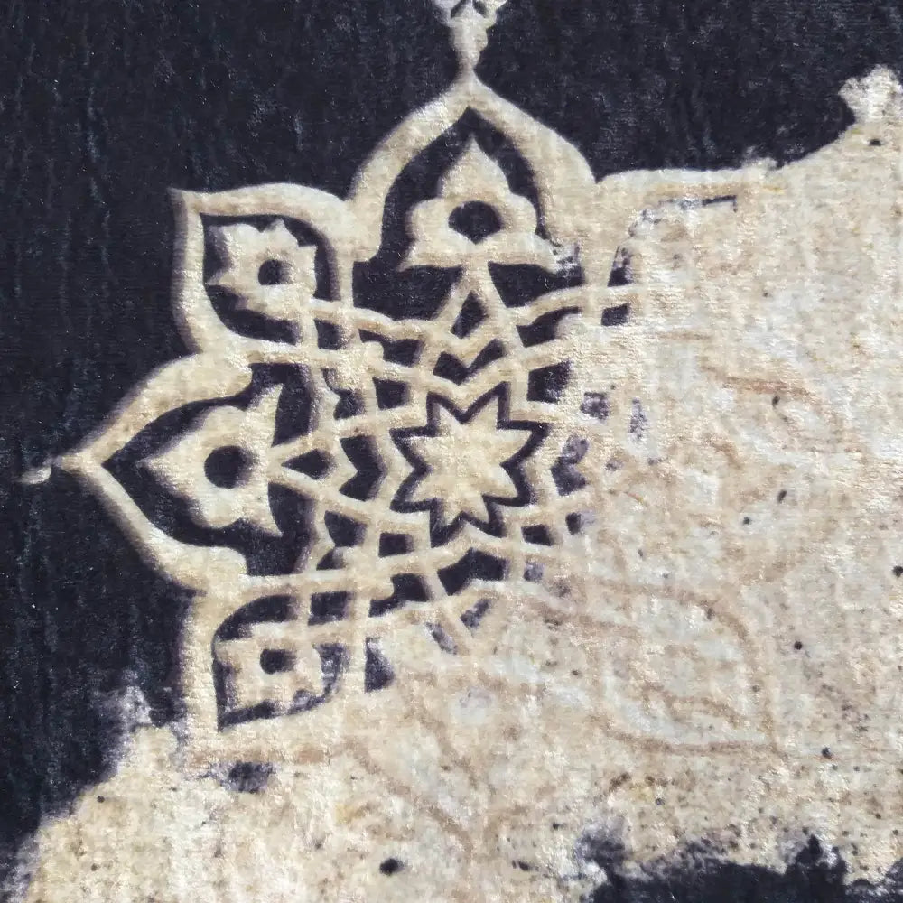 Tepe svart og gull teppe, nærbilde av orientalsk mønster i svart og beige med tydelig tekstur.