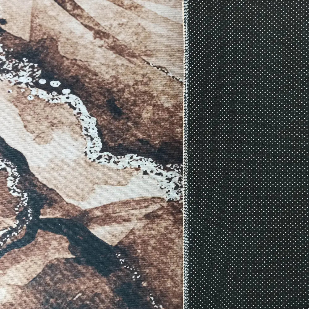 Tepe tekstil til Horeca, nærbilde av brunmønstret stoff og mørk del med hvite prikker og markert søm.