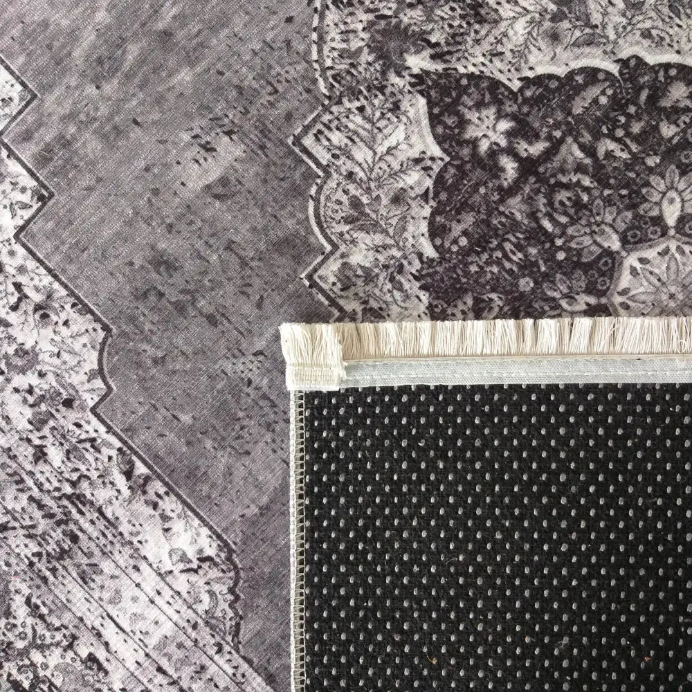 Tepe Vintage 200 grått teppe, nærbilde av hjørne med hvite frynser og sklisikkert gummibelegg.