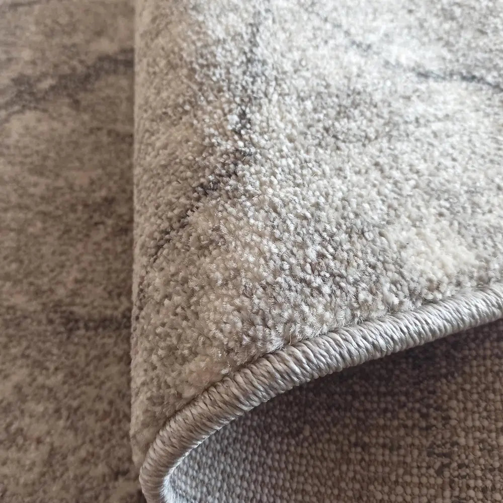 Tepe Vista 08 grått teppe, nærbilde som fremhever tettvevd lugg, tykkelse og detaljert kantsøm.