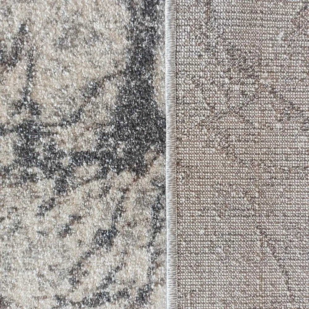 Tepe Vista 08 grått teppe, nærbilde av marmormønster foran og grovvevd bakside i beige og grå nyanser.