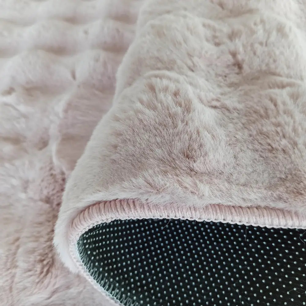 Tepedesign Merlin 3D rosa, nærbilde som viser myk, fluffy tekstur, sorte antiskli-prikker og pent sydd kant.