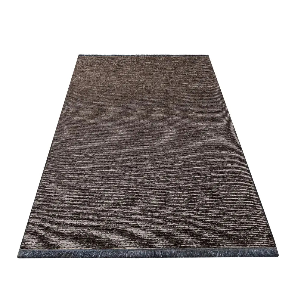 Tepedrøm Diamond, mørkebrunt teppe med diskret striper og frynser langs kortsiden, sett fra skrå vinkel.