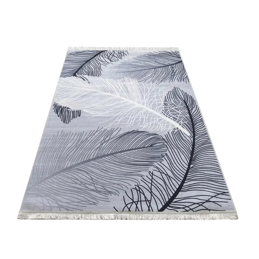 Grått supermykt teppe 120 x 180 cm, skråvisning med grafisk bladmotiv og frynser på kortsidene.