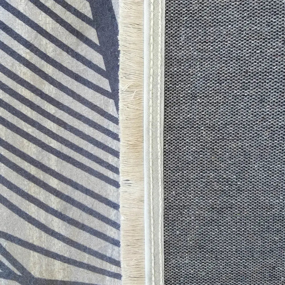 Tepesalong Kvalitet Supermykt, nærbilde av gråstripet tekstil med frynser ved siden av ensfarget grå vev.