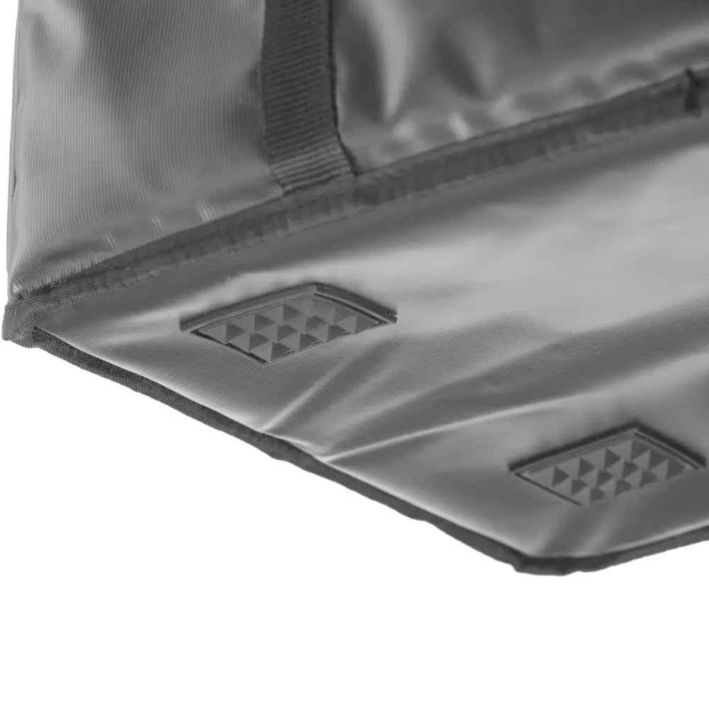 Termisk leveringsveske, nærbilde av grått nylonstoff med sorte gummierte felter og synlig søm i hjørnet.