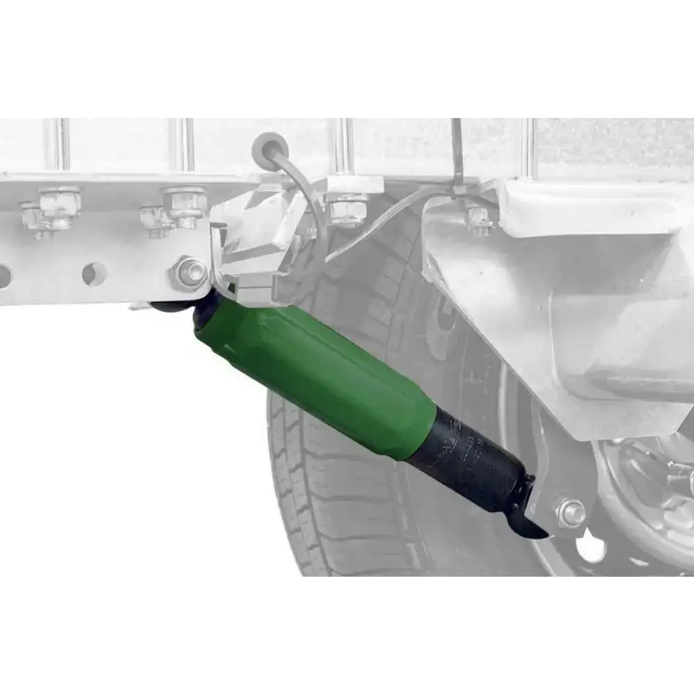 Tilhengeraksel støtdemper AL-KO Octagon grønn, montert under kjøretøy med synlig hjuloppheng og rammedetaljer.