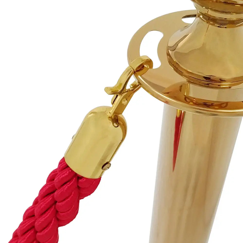 Blank gullfarget hotellavsperringsstolpe med rød flettet tau og detaljert metallfeste, nærbilde.