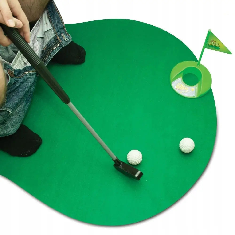 Toalettgolf sett med grønn putting-matte, minigolfkølle, to baller og hull med flagg, person i sokker.