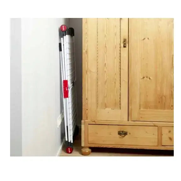 Tørkestativ for klær XXL Vileda Infinity 3M, sammenleggbart med svarte og røde detaljer ved lys vegg og treskap.