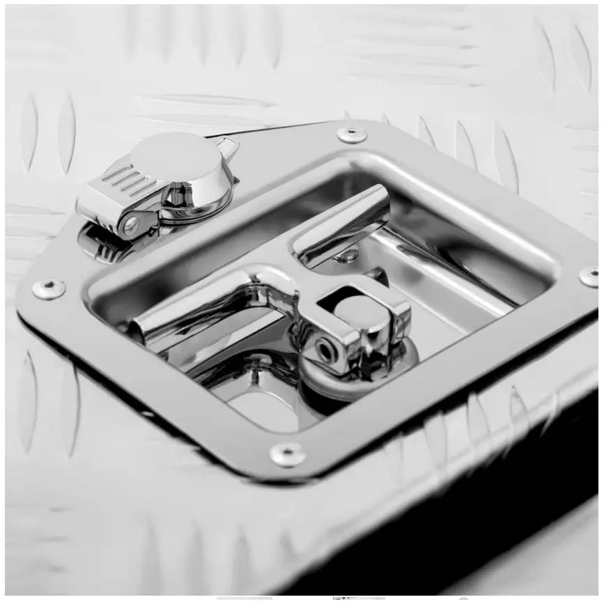 Transportabel verktøykasse i aluminium, nærbilde av låsemekanisme med håndtak og riflet metallstruktur.