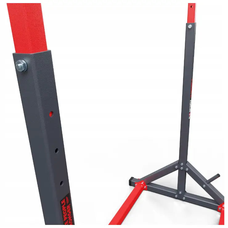 Treningsstang stasjonær, nærbilde av grå og rød justerbar metallramme med detaljerte bolter og støttestag.