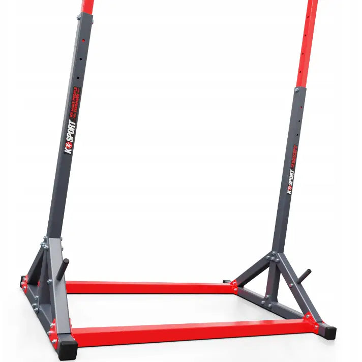 Treningsstang stasjonær, detalj av grå og rød metallramme med bolter og justeringshull, sett skrått nedenfra.