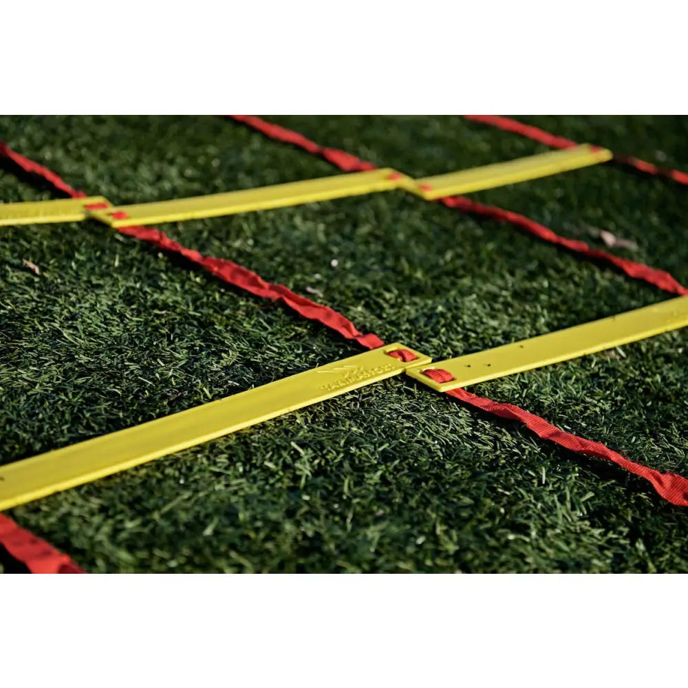 Tretrinns 3D koordineringsstige, nærbilde av gul plast og røde bånd på kunstgress med tydelig materialstruktur.
