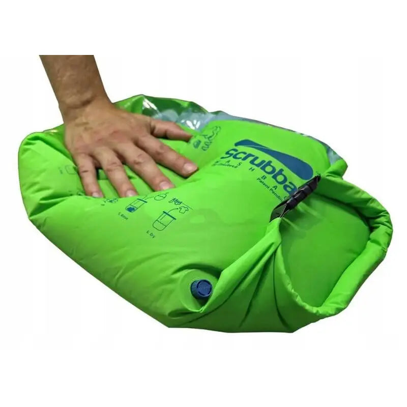 Turistisk Vaskepose Vask Bag Scrubba, lysegrønn nylonpose med blå ventil og instruksjoner, trykkes sammen.