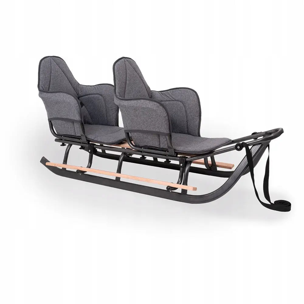 Tvillingpulk med madrass, sidebilde som viser grå, polstrede seter, høye rygger og sorte metallmeder.