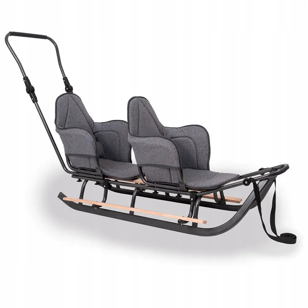 Tvillingvogn med dyttestang, svart metallramme, grå polstrede seter og høye ryggstøtter sett fra siden.