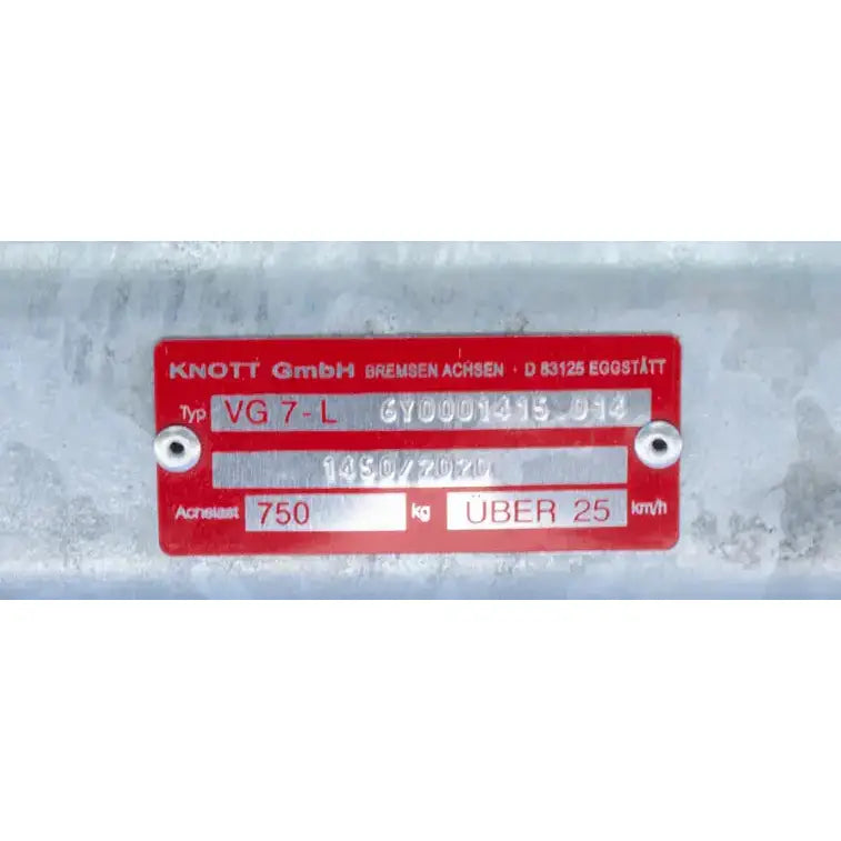 Aksling tilhenger, nærbilde av rød og sølv etikett med gravert teknisk informasjon på galvanisert stål.