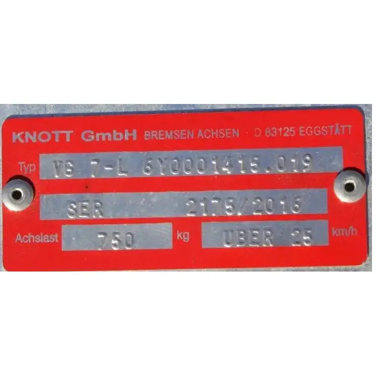 Aksling tilhenger KNOTT VG7, nærbilde av rødt metallskilt med preget spesifikasjonstekst og firmalogo.