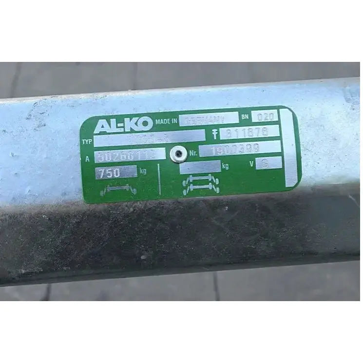 Aksling tilhenger AL-KO, nærbilde av grønt og hvitt navneskilt med spesifikasjoner og logo på metallrør.