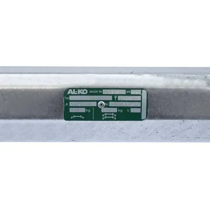 Aksling for tilhenger, frontbilde av galvanisert rør med grønt og hvitt skilt med tekniske spesifikasjoner.