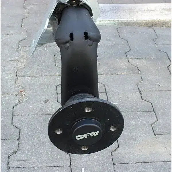 Aksling tilhenger AL-KO, skråvisning av sort metallaksel med fem bolthull og synlig AL-KO-logo på navkapsel.