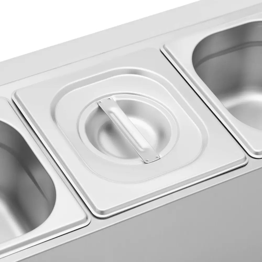 Utstillingstativ GN 1/6, nærbilde av rustfri beholder med lokk og håndtak, omgitt av åpne beholdere.