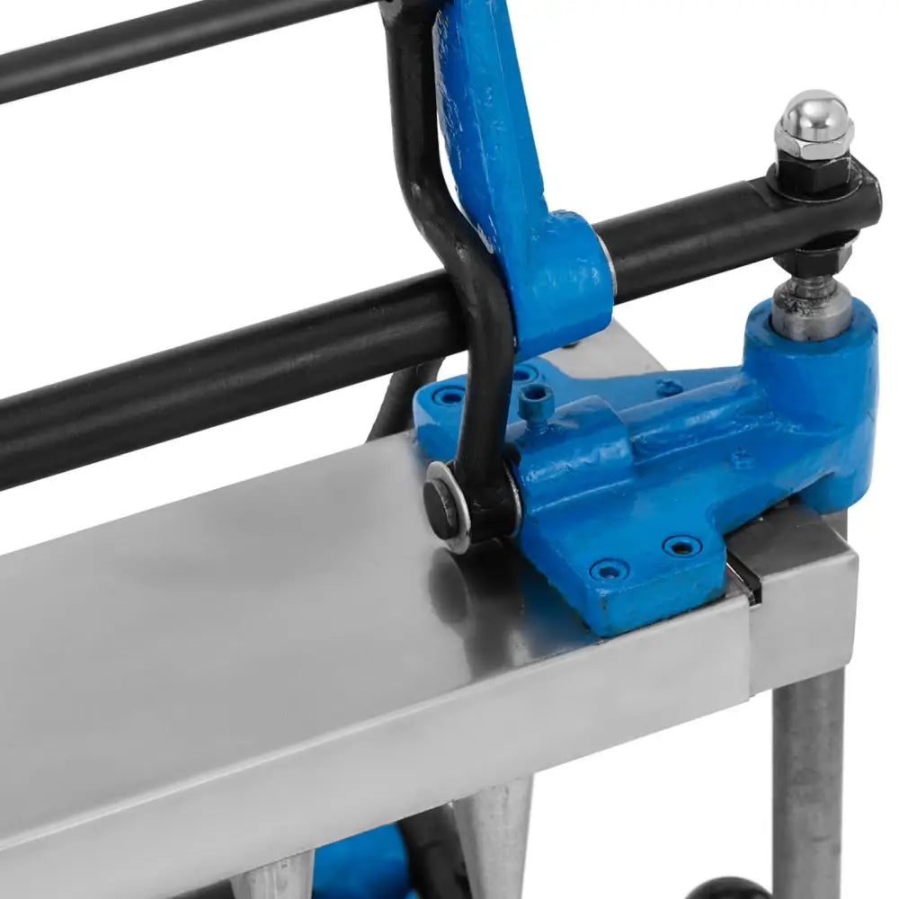 Vafeljern maskin, nærbilde av blå og svarte metalldeler med ledd og bolter på børstet metalloverflate.