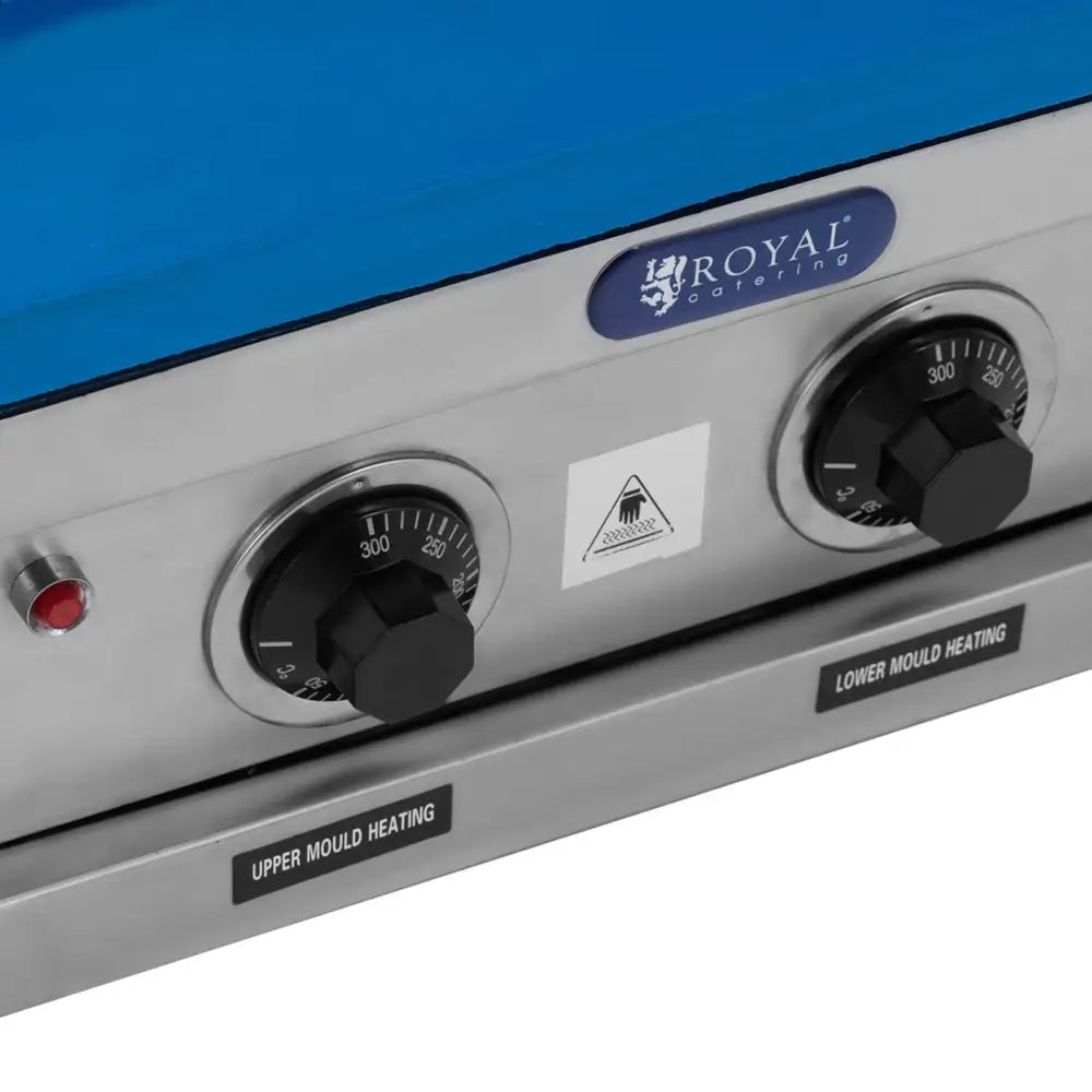 Vafeljern maskin, nærbilde av kontrollpanel med to sorte temperaturbrytere og tydelig varmeindikasjon.