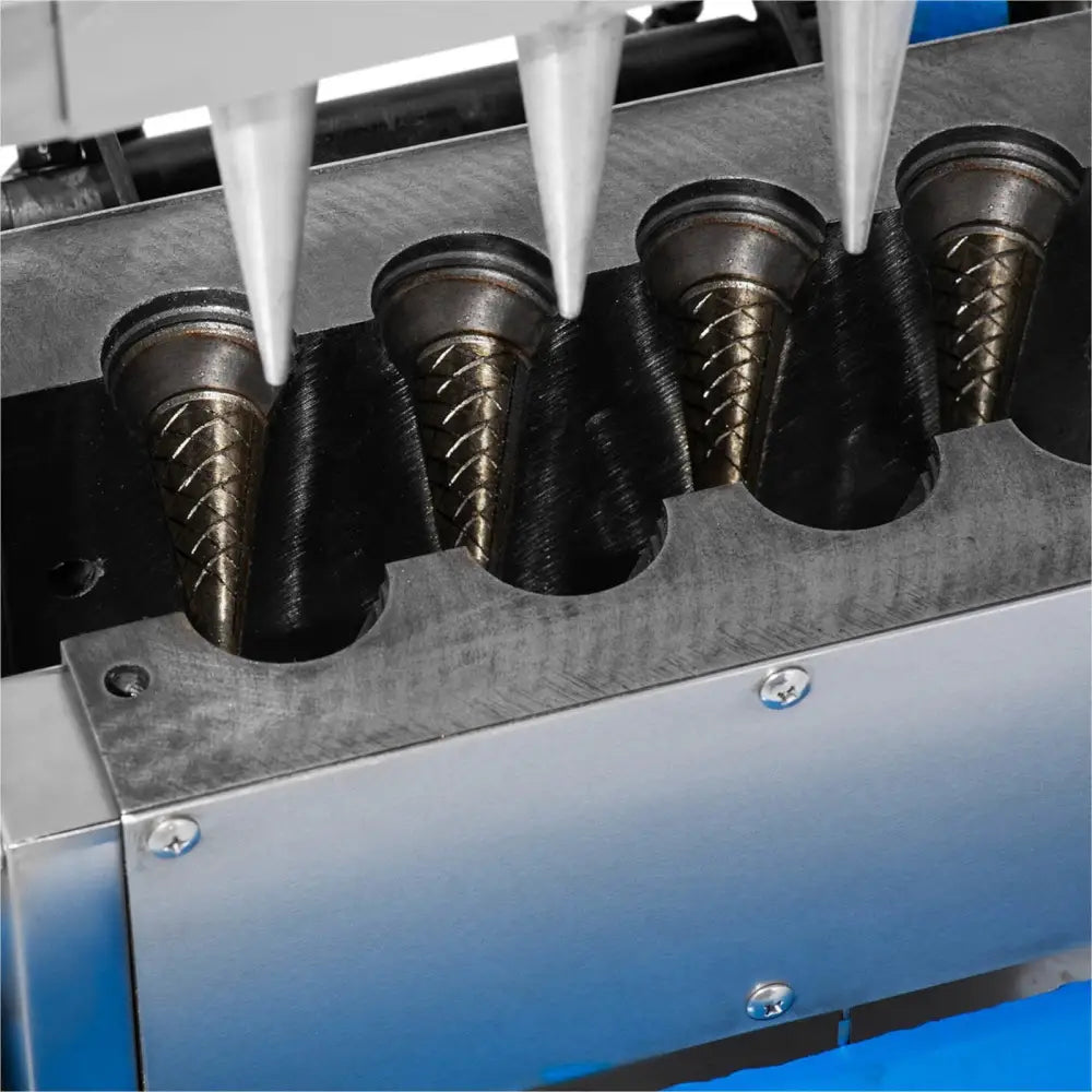 Vafeljern for iskjekks, nærbilde av metallformer med kjeks og fyllingstuter, industrielt stål.