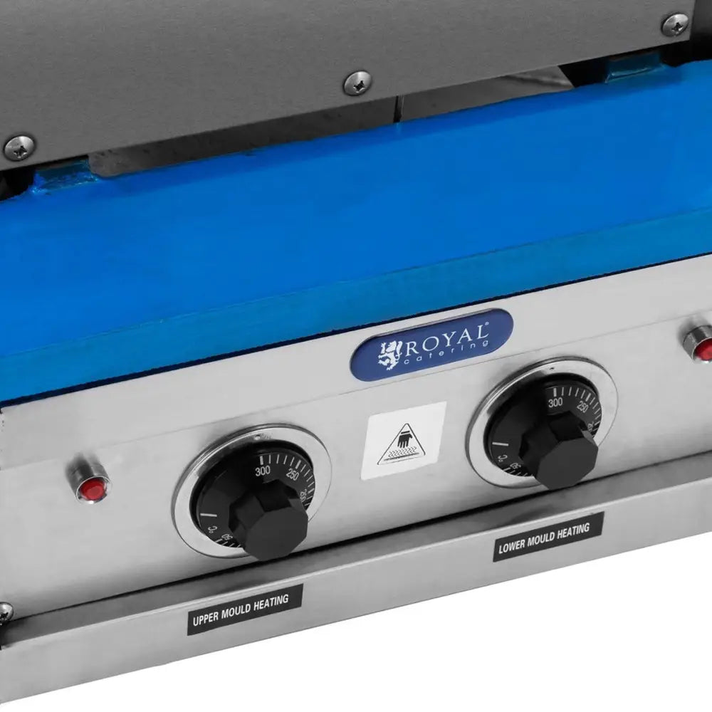 Vaffelpresse for iskremkjeks, nærbilde av kontrollpanel med to svarte brytere, blå beskyttelsesfilm og merkeetikett.