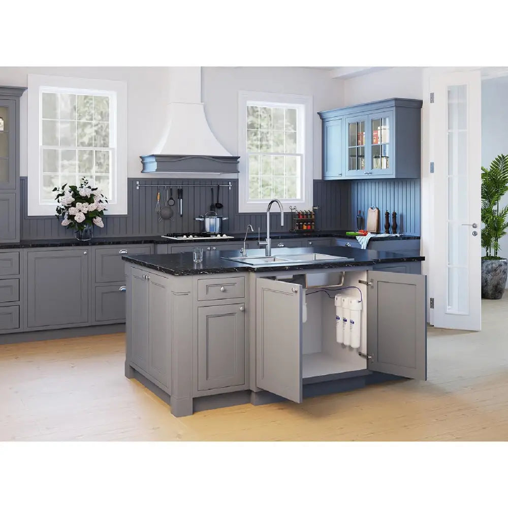 Vannfiltersett med kran installert under kjøkkenvask, synlig gjennom åpne skapdører på grå kjøkkenøy.