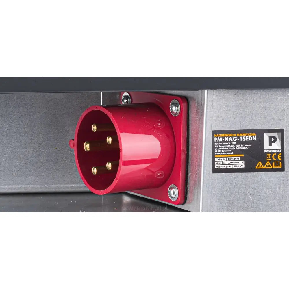 Varmevifte industrikontakt, nærbilde av rød kontakt med fem messingpinner på grå metallflate, informasjonsmerke synlig.