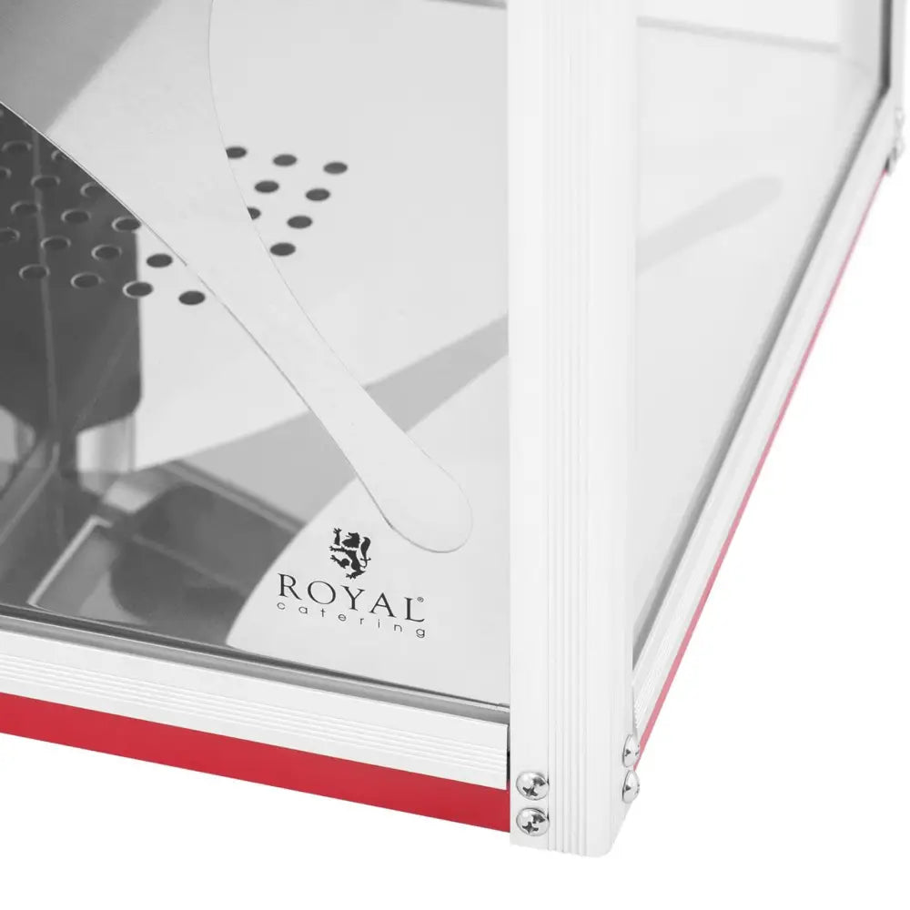 Varmevinduskåpe for nachos- og popcornvarmer, detalj av glasshjørne, røde detaljer og Royal Catering-logo.