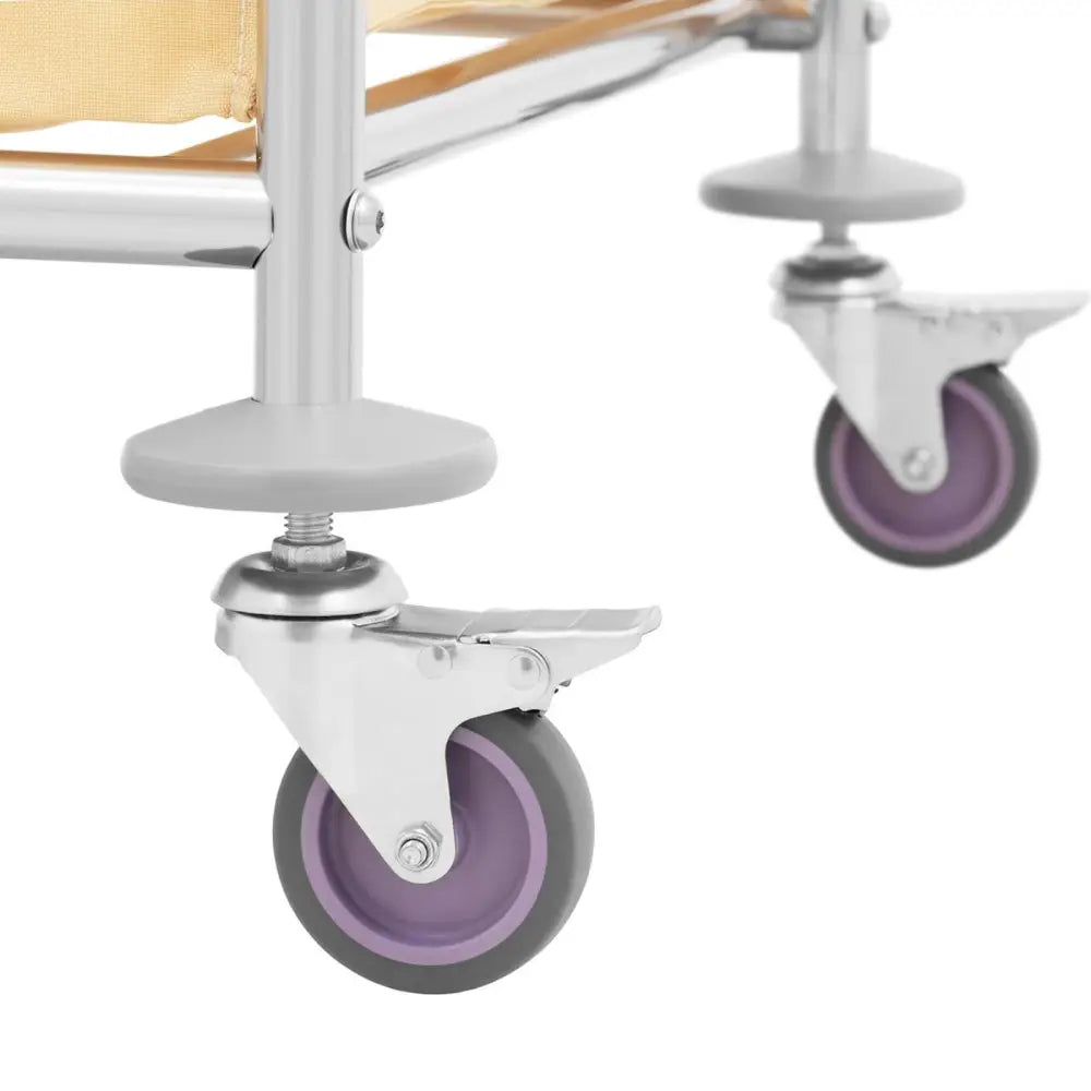 Vaskeriservice vogn, nærbilde av grålilla gummihjul på metallramme med bremser og beige tekstilpose.