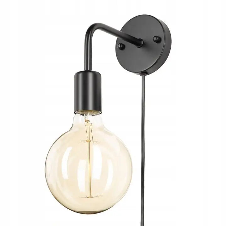 Vegglampe i svart metall med rund glasspære, sett fra siden med hengende ledning mot lys bakgrunn.