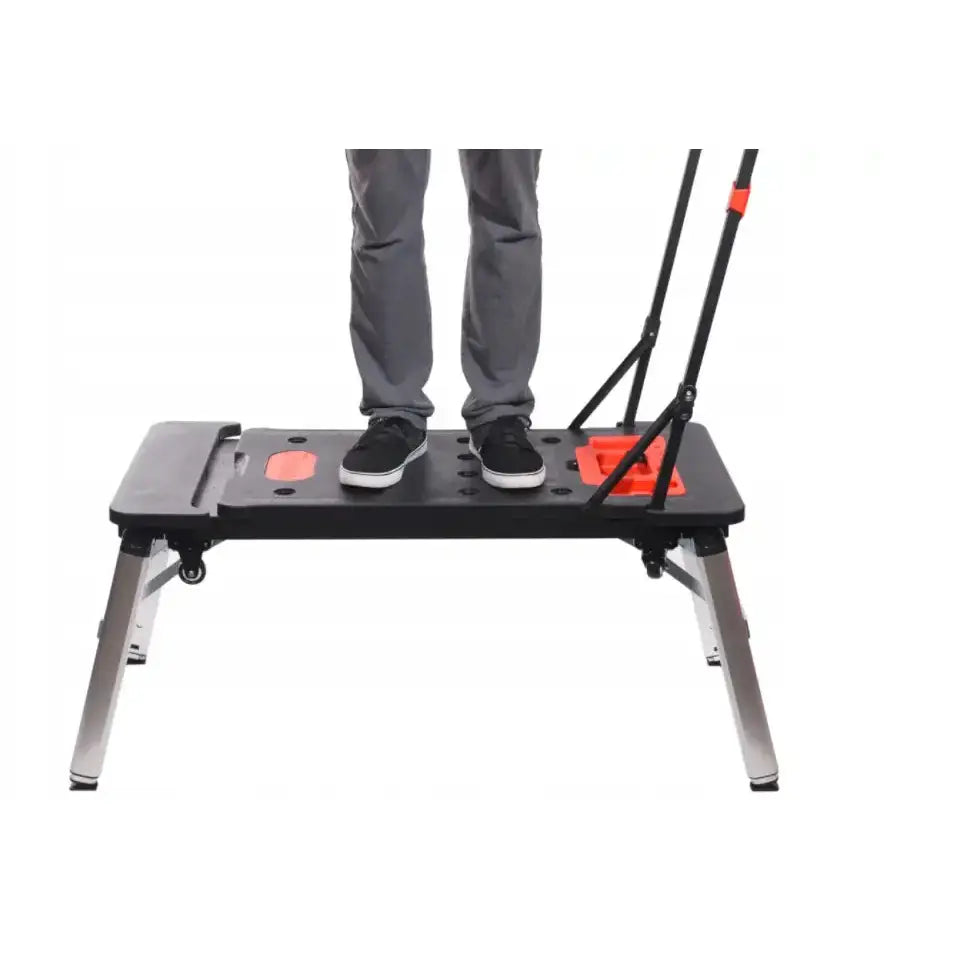 Verkstedbord Universal 7 i 1, sidevisning med person som står på plattformen, røde detaljer og håndtak synlige.