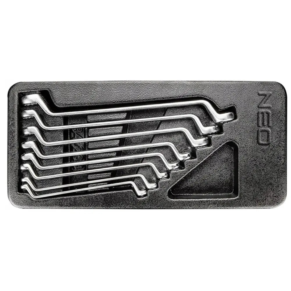 Syv sekskantnøkler i blankt metall, ordnet i svart plastform med strukturert overflate, sett ovenfra.