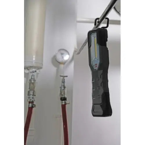 Verkstedslampe med LED-panel, svart rektangulær design hengt på metallrør, markerte gripeflater i industrimiljø.