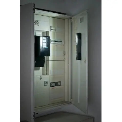 Hvit sikringsboks med åpen dør, skrått sett, viser flere sikringer og en mørk modul på innsiden.