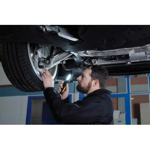 Verkstedslampe LED, vist i bruk under bilinspeksjon, holdt av mekaniker i aktivt verkstedmiljø.